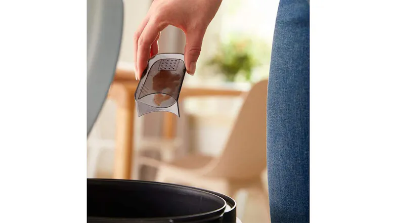 A hand throwing a fuzz from the shaver’s bin A hand throwing a fuzz from the shaver’s bin