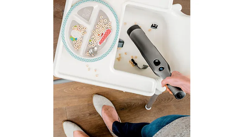 A view of the unit being used to clear out spilled food on a kid's high chair A view of the unit being used to clear out spilled food on a kid's high chair