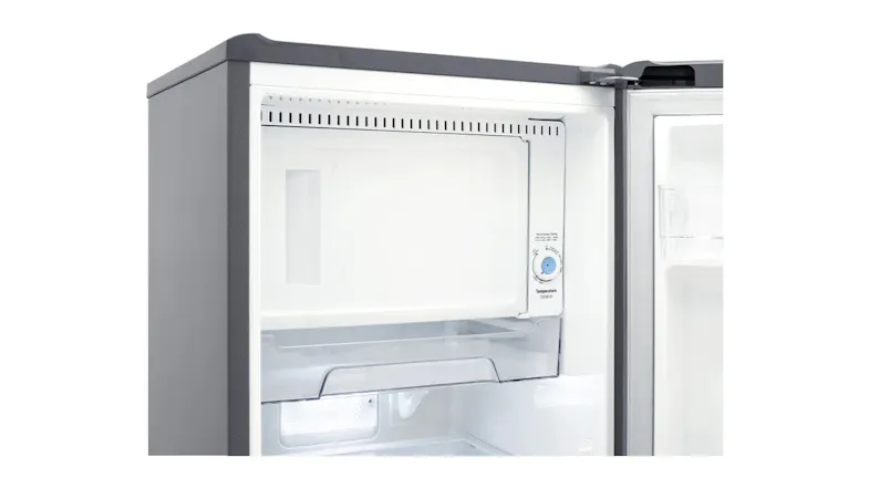 Close-up of freezer compartment inside the fridge, showing temperature control dial and storage area Close-up of freezer compartment inside the fridge, showing temperature control dial and storage area