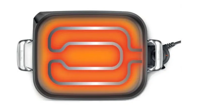 Profile view of an electric skillet showing its glowing internal heating element pattern Profile view of an electric skillet showing its glowing internal heating element pattern