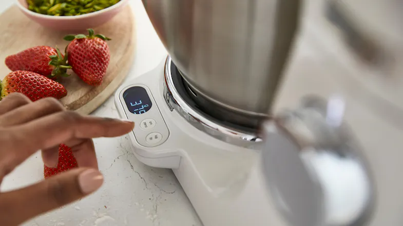 Close‑up of a hand pressing buttons on the built‑in digital weighing scale at the base of the Titanium Chef Baker XL Close‑up of a hand pressing buttons on the built‑in digital weighing scale at the base of the Titanium Chef Baker XL