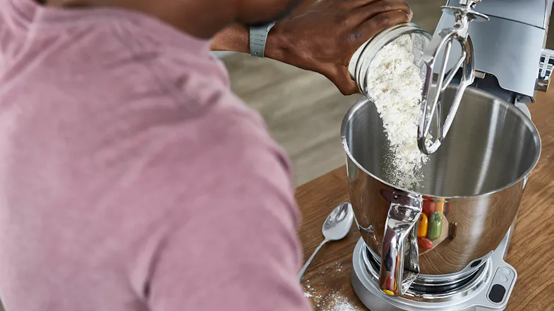 Person pouring flour from a jar into the stainless‑steel bowl of the silver Titanium Chef Baker XL Person pouring flour from a jar into the stainless‑steel bowl of the silver Titanium Chef Baker XL