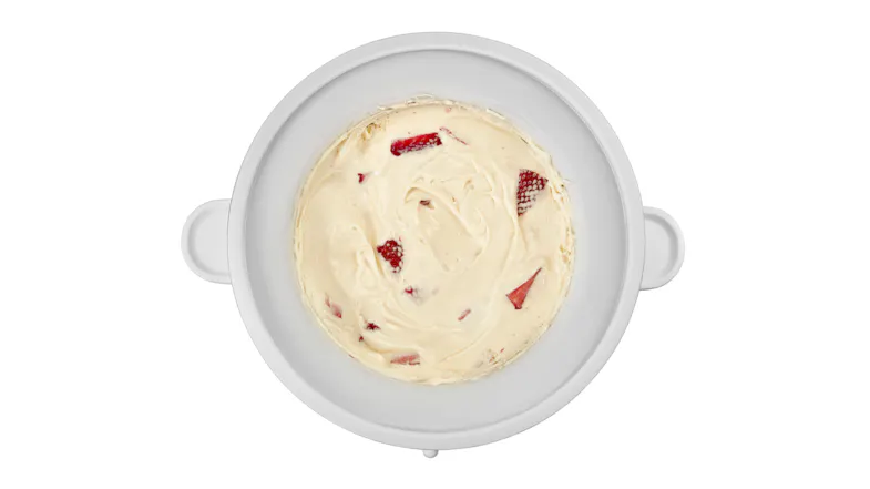 Overhead shot of a KitchenAid ice cream mixer bowl containing homemade strawberry ice cream Overhead shot of a KitchenAid ice cream mixer bowl containing homemade strawberry ice cream
