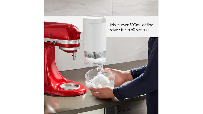 A KitchenAid mixer quickly filling a large glass bowl with light, fluffy shaved ice A KitchenAid mixer quickly filling a large glass bowl with light, fluffy shaved ice