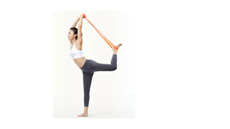 A person is balancing in a yoga pose while stretching with an orange resistance band looped around one foot A person is balancing in a yoga pose while stretching with an orange resistance band looped around one foot