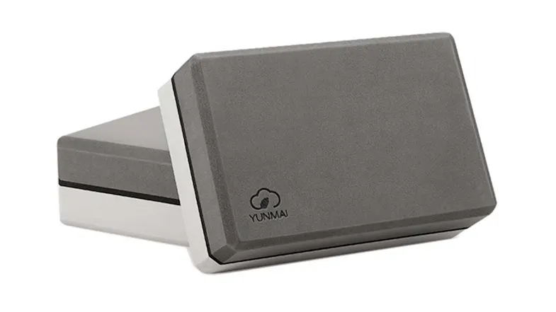 Close-up of two gray-and-white rectangular yoga foam blocks, with one displaying the YUNMAI logo Close-up of two gray-and-white rectangular yoga foam blocks, with one displaying the YUNMAI logo