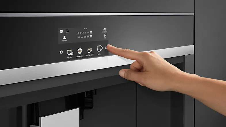 A hand pressing buttons on a coffee machine’s control panel. A hand pressing buttons on a coffee machine’s control panel.