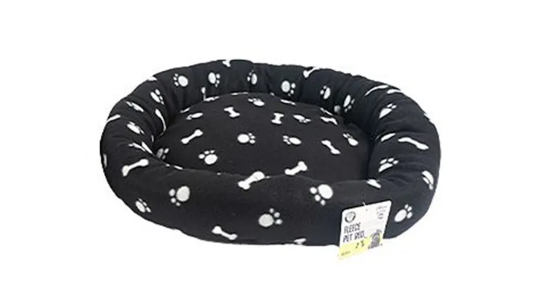 Round black fleece pet bed with a padded rim and white paw print pattern Round black fleece pet bed with a padded rim and white paw print pattern