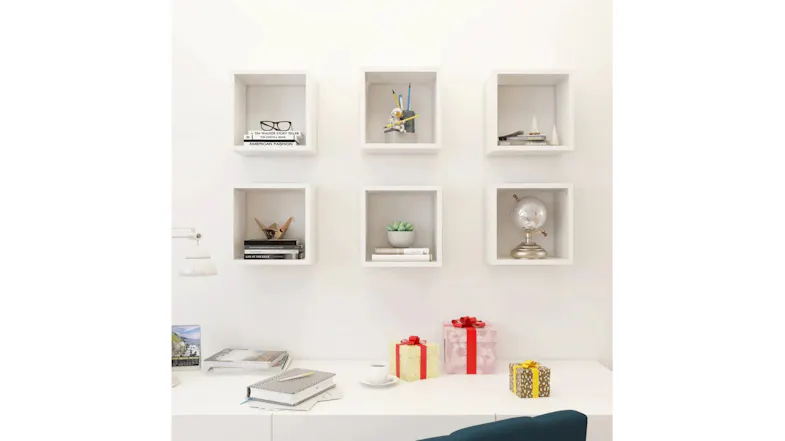 Gloss white cube wall shelves mounted above a sofa, styled with books and a small plant Gloss white cube wall shelves mounted above a sofa, styled with books and a small plant