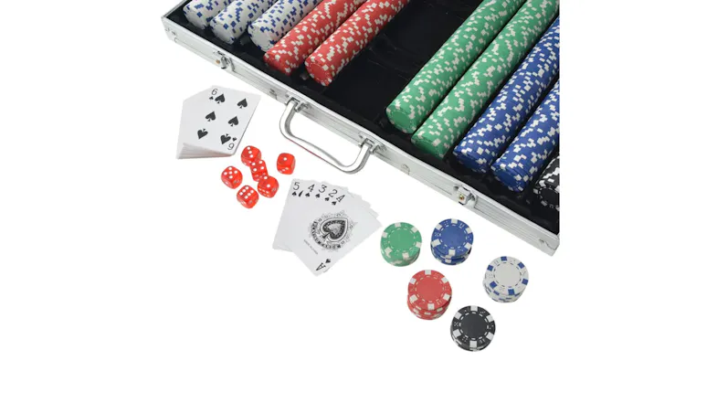 Close-up of an NNEVL poker set with colourful chips, red dice, and playing cards scattered near the silver case handle Close-up of an NNEVL poker set with colourful chips, red dice, and playing cards scattered near the silver case handle