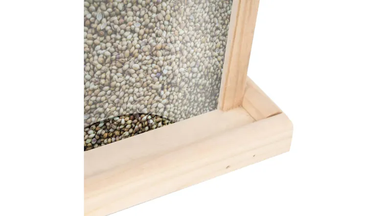 A close up view of the bird feeder filled with food A close up view of the bird feeder filled with food
