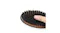 A finger pressing into the black‑bristle side of a wooden hairbrush A finger pressing into the black‑bristle side of a wooden hairbrush