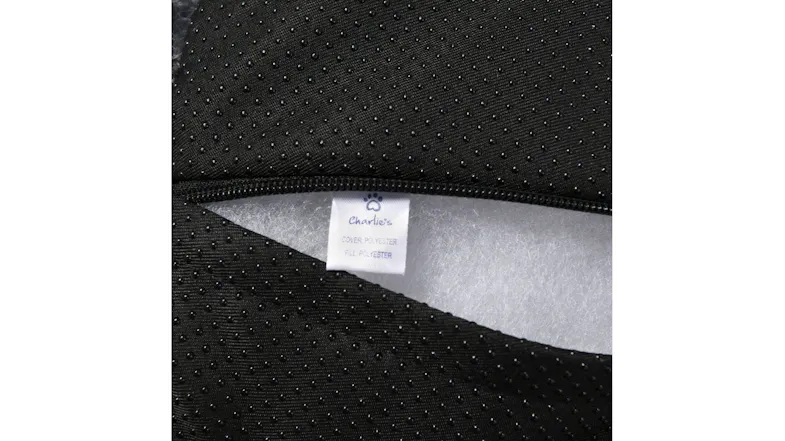 Close-up of an unzipped black pet bed cover showing the inner padding and a fabric care label Close-up of an unzipped black pet bed cover showing the inner padding and a fabric care label