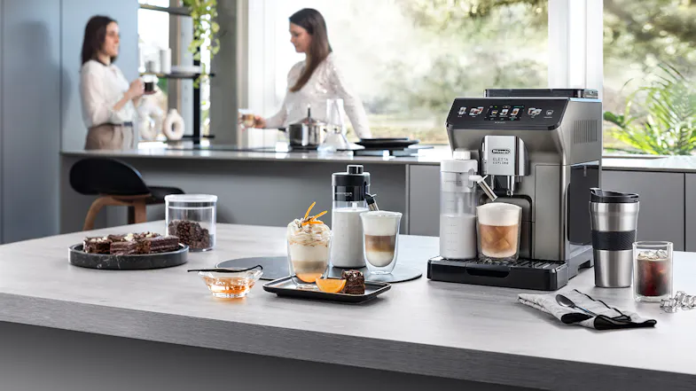 A modern kitchen counter with a coffee machine, drinks, desserts, and two people talking A modern kitchen counter with a coffee machine, drinks, desserts, and two people talking
