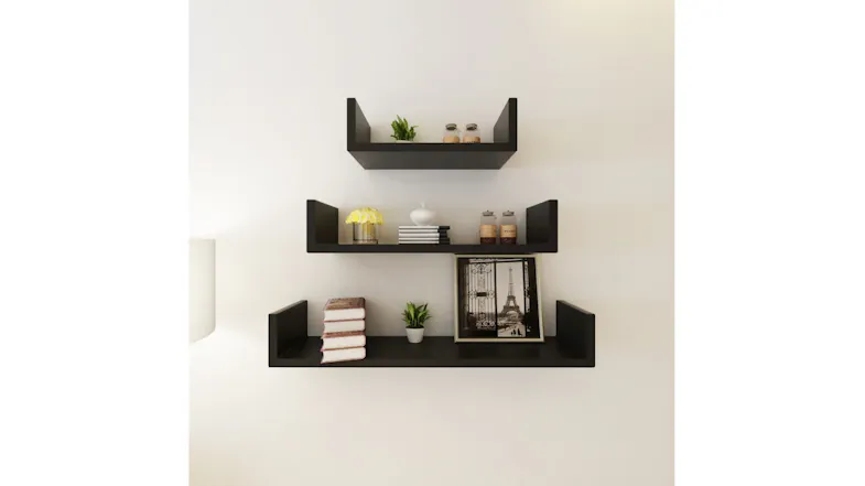 Three black NNEVL U-shaped floating shelves mounted on a wall, decorated with plants, books, and a framed picture Three black NNEVL U-shaped floating shelves mounted on a wall, decorated with plants, books, and a framed picture