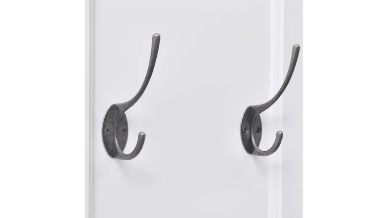 Close-up of dual wall hooks in dark metal finish on white coat rack board Close-up of dual wall hooks in dark metal finish on white coat rack board