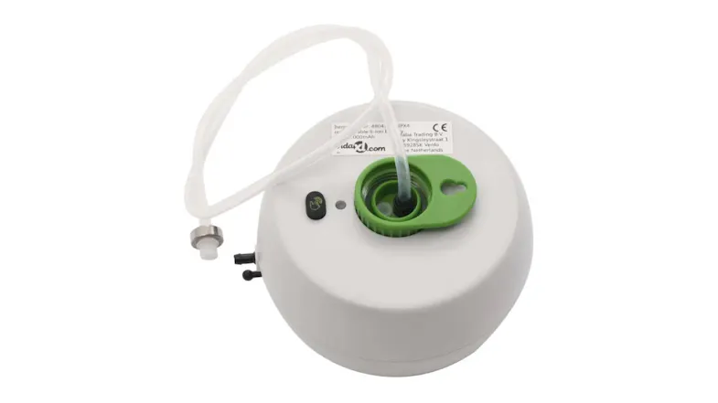 Rear view of a round irrigation timer showing tubing attached to a green port, power button, and label on a white casing Rear view of a round irrigation timer showing tubing attached to a green port, power button, and label on a white casing