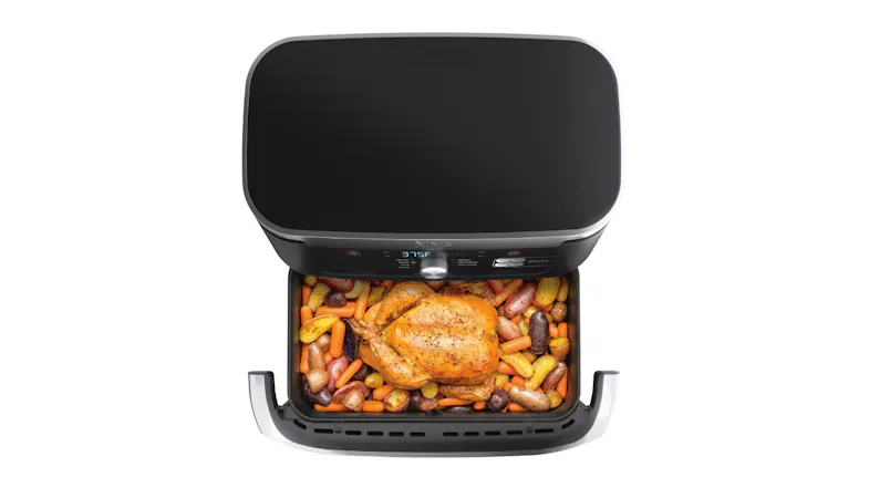 Open Ninja air fryer filled with roasted chicken, potatoes, and carrots Open Ninja air fryer filled with roasted chicken, potatoes, and carrots