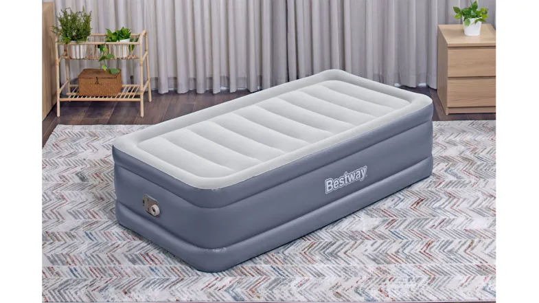 Bestway twin air mattress in bedroom scene with side table, plants, and curtains Bestway twin air mattress in bedroom scene with side table, plants, and curtains