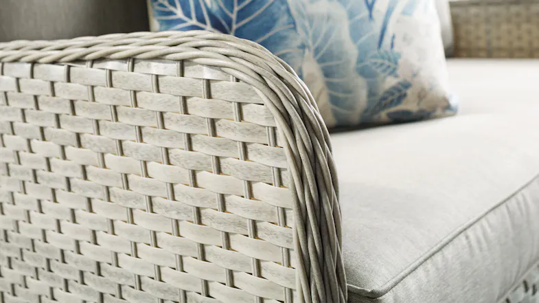 Close‑up of an Arizona patio chair arm, showing the light‑grey woven wicker texture and smooth cushion fabric Close‑up of an Arizona patio chair arm, showing the light‑grey woven wicker texture and smooth cushion fabric