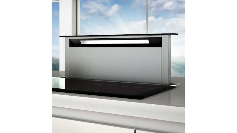 Close view of the raised downdraft rangehood behind a cooktop, emphasising black glass top panel Close view of the raised downdraft rangehood behind a cooktop, emphasising black glass top panel