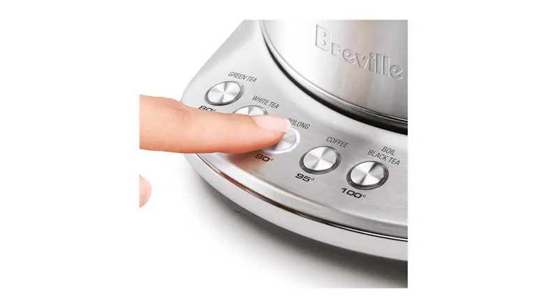 Close‑up of a hand pressing the ‘Oolong 90°’ temperature preset button on the brushed stainless steel base Close‑up of a hand pressing the ‘Oolong 90°’ temperature preset button on the brushed stainless steel base