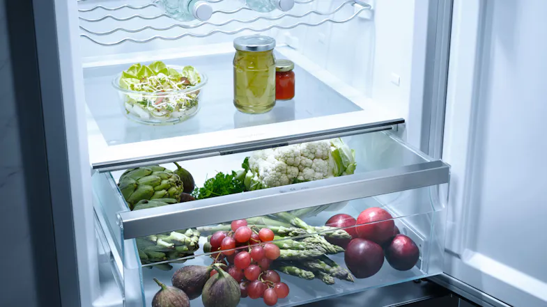 Lower fridge section with drawers storing fresh vegetables like cauliflower, asparagus, grapes, and figs Lower fridge section with drawers storing fresh vegetables like cauliflower, asparagus, grapes, and figs