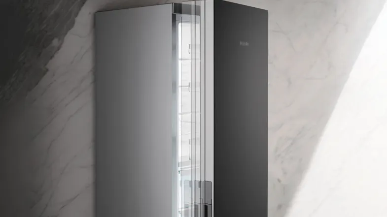 Close-up view of a partially open Miele 399L silver smart fridge, showing sleek stainless steel doors Close-up view of a partially open Miele 399L silver smart fridge, showing sleek stainless steel doors