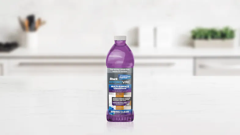A Shark HydroVac Multi‑Surface Cleaner bottle stands upright on a white countertop in a modern kitchen A Shark HydroVac Multi‑Surface Cleaner bottle stands upright on a white countertop in a modern kitchen