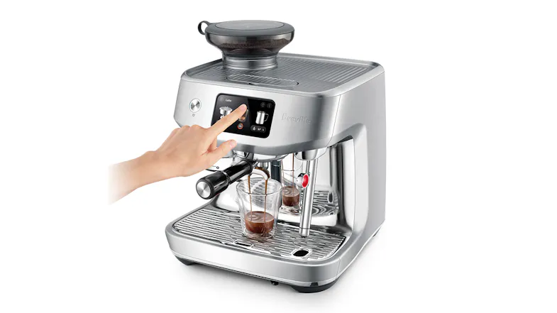 A hand is pressing a button on a stainless steel espresso machine as two glasses fill with espresso A hand is pressing a button on a stainless steel espresso machine as two glasses fill with espresso