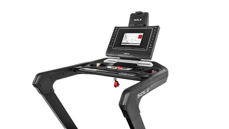 Close-up of SOLE treadmill dashboard with digital screen, safety key, and built-in storage compartments Close-up of SOLE treadmill dashboard with digital screen, safety key, and built-in storage compartments