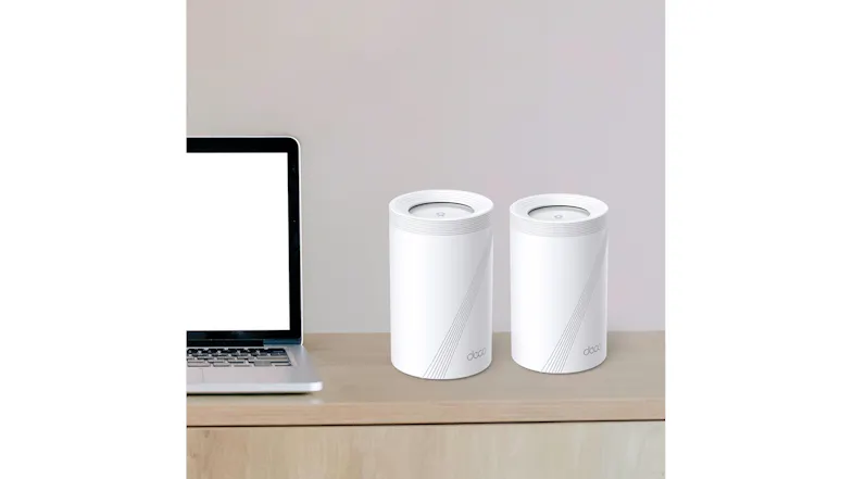 View of two Deco BE65 Wi-Fi 7 units next to a laptop with a table. View of two Deco BE65 Wi-Fi 7 units next to a laptop with a table.
