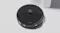 Top-view image of a black robot vacuum on a light surface, showing its control buttons and LiDAR navigation sensor Top-view image of a black robot vacuum on a light surface, showing its control buttons and LiDAR navigation sensor