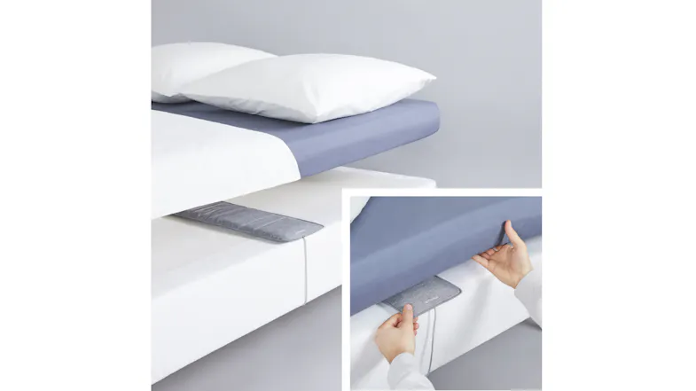 A person setting up the Sleep Analyser mat by sliding it between the mattress and sheet A person setting up the Sleep Analyser mat by sliding it between the mattress and sheet