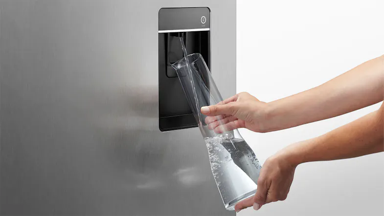 A hand filling a water jug via the unit's external dispenser A hand filling a water jug via the unit's external dispenser