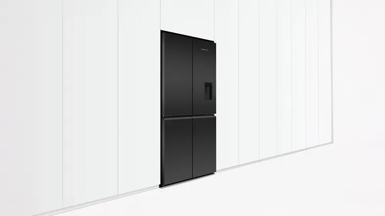 Angled view of a quad door fridge in black glass with water dispenser, placed against a white wall Angled view of a quad door fridge in black glass with water dispenser, placed against a white wall