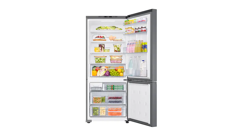 Open Samsung fridge freezer filled with assorted food items and frozen goods in organised compartments Open Samsung fridge freezer filled with assorted food items and frozen goods in organised compartments