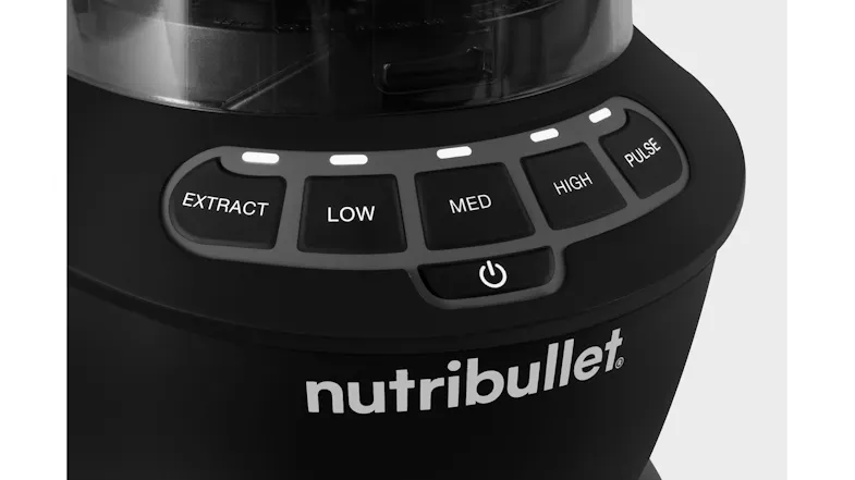 Close-up of the Ninja blender base with a clear cup locked in place, showing the stainless-steel blades positioned inside the cup Close-up of the Ninja blender base with a clear cup locked in place, showing the stainless-steel blades positioned inside the cup