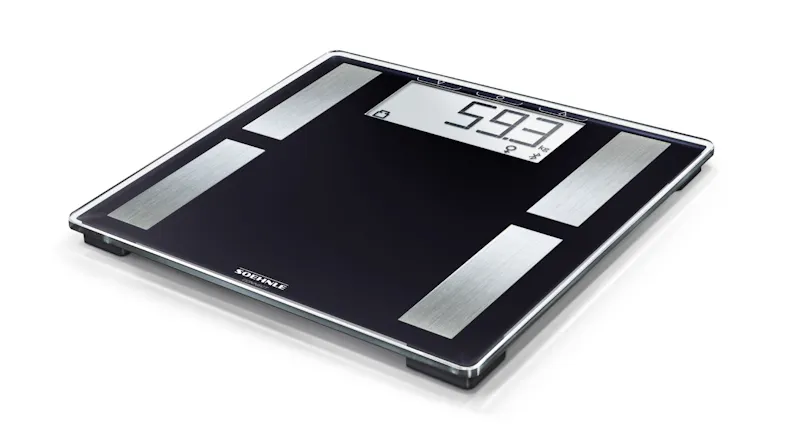 Angled view of a black bathroom weighing scale with metal sensors and LCD showing 59.3 kg Angled view of a black bathroom weighing scale with metal sensors and LCD showing 59.3 kg