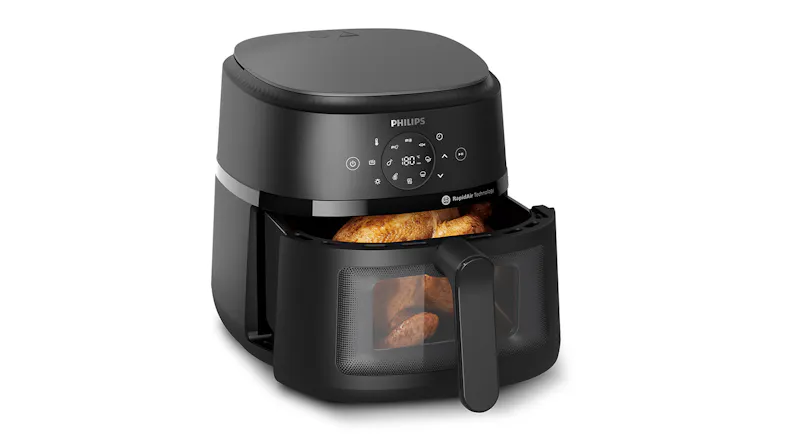 Philips air fryer with its basket open, showing cooked food inside Philips air fryer with its basket open, showing cooked food inside