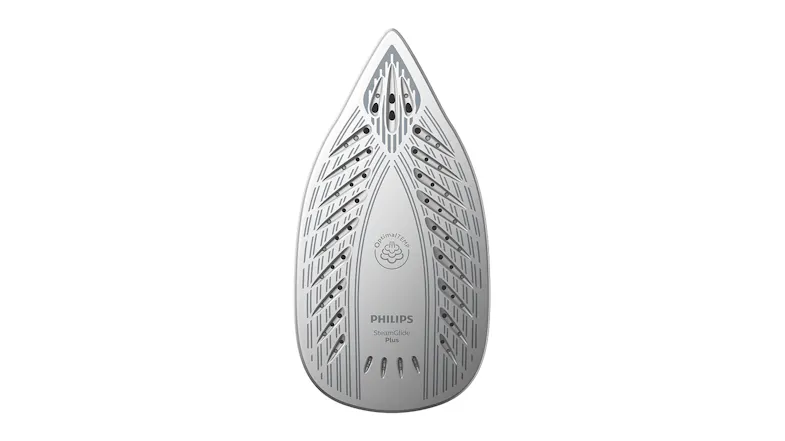 A close-up of an iron's silver soleplate with steam holes and a patterned design A close-up of an iron's silver soleplate with steam holes and a patterned design