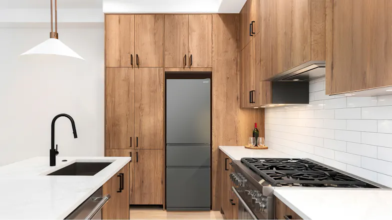 The fridge freezer installed flush along wooden cabinetries The fridge freezer installed flush along wooden cabinetries