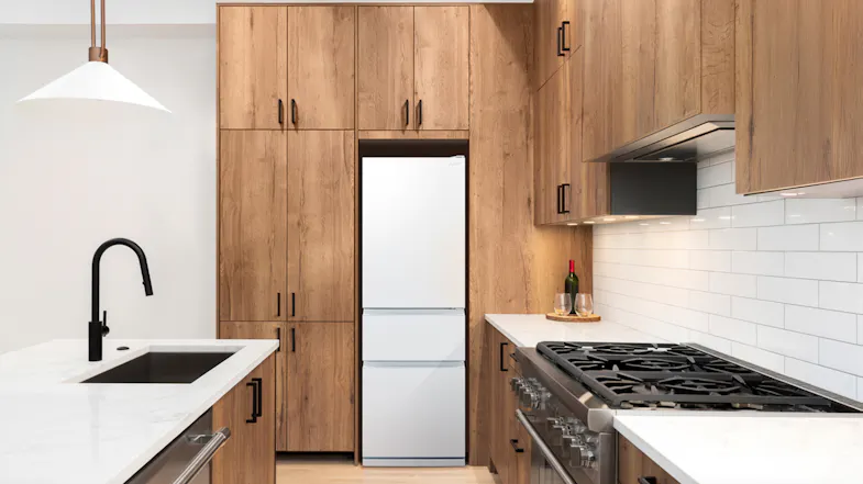 The fridge freezer installed flush along wooden cabinetries The fridge freezer installed flush along wooden cabinetries