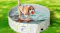 A dog standing in a water‑filled pet pool with an avocado print on a grassy lawn, holding an orange ball A dog standing in a water‑filled pet pool with an avocado print on a grassy lawn, holding an orange ball