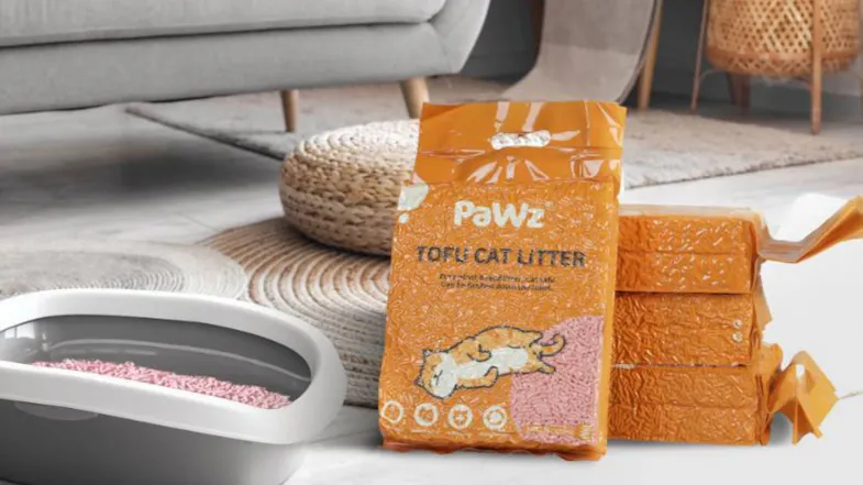 PaWz tofu cat litter bag stacked with sealed packs next to a litter tray filled with pellets in a modern indoor room setting PaWz tofu cat litter bag stacked with sealed packs next to a litter tray filled with pellets in a modern indoor room setting