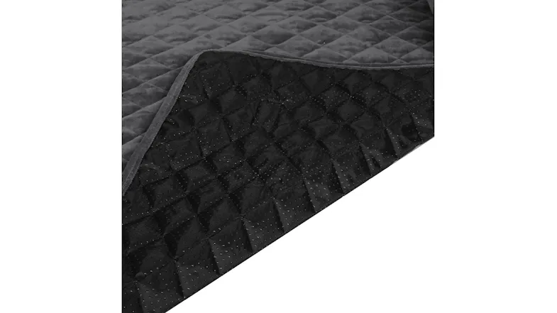 Close-up of a quilted pet bed with a corner lifted to show the textured, non-slip underside Close-up of a quilted pet bed with a corner lifted to show the textured, non-slip underside