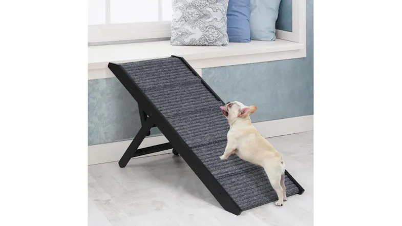 A dog is climbing a black pet ramp. A dog is climbing a black pet ramp.