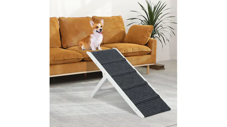 A dog is sitting on a couch with a textured grey pet ramp. A dog is sitting on a couch with a textured grey pet ramp.