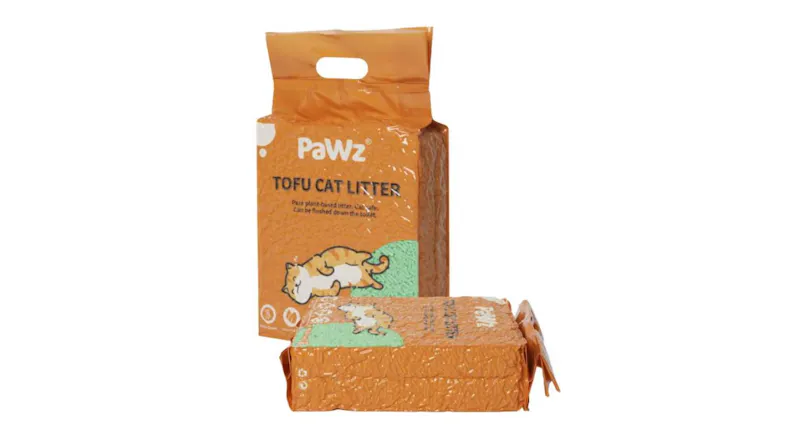 A cat litter pack standing upright beside a sealed pack laid flat, featuring orange packaging and green tofu pellets A cat litter pack standing upright beside a sealed pack laid flat, featuring orange packaging and green tofu pellets