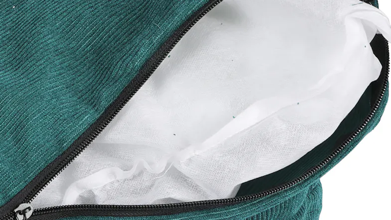 Close-up of a green corduroy cover unzipped to reveal a white fabric inner cushion inside Close-up of a green corduroy cover unzipped to reveal a white fabric inner cushion inside